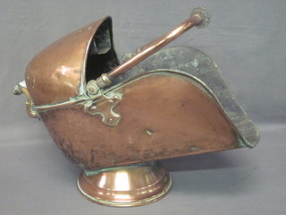 A Victorian copper helmet shaped coal scuttle with glass handle,  raised on a circular spreading foot