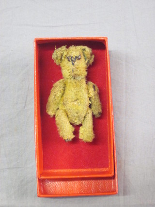 A miniature yellow teddybear with articulated limbs 2"