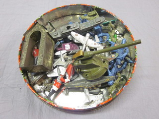 A round biscuit tin containing various model figures, sentry box etc,