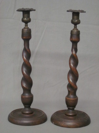 A pair of oak spiral turned candlesticks with metal sconces 15"