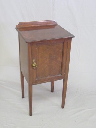 A mahogany bedside cabinet with raised back enclosed by a  panelled door, raised on square tapering supports 16"