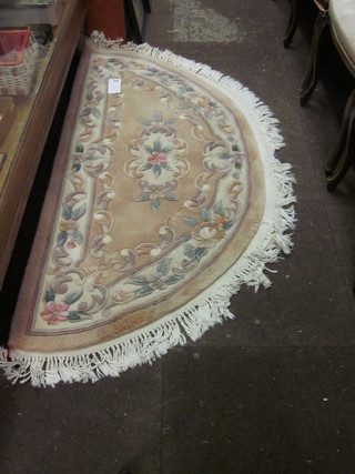 A crescent shaped cream ground and floral patterned Chinese hearth rug 57" x 28"