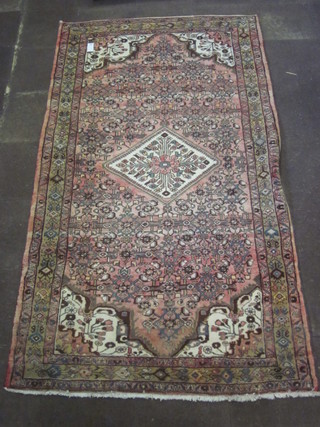 A contemporary pink ground and floral patterned Persian rug with diamond shaped medallion to the centre, 122" x 67"