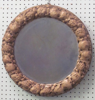 A circular bevelled plate wall mirror contained in a wooden frame decorated fruit 15"