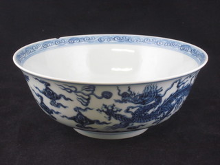 An Oriental circular blue and white porcelain bowl decorated a dragon, the base with 6 character mark, chip to rim, 8 1/2"