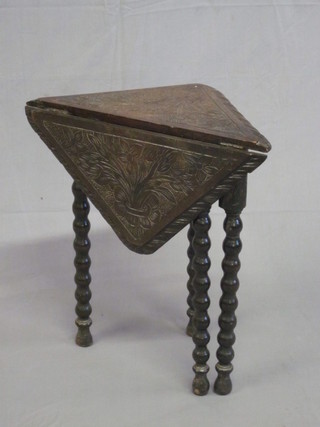 A Victorian heavily carved oak drop flap corner table, raised on bobbin turned supports 20"