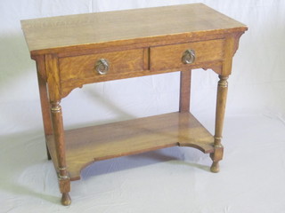 An Art Nouveau honey oak side table fitted 2 short drawers,  raised on turned supports with undertier 36"