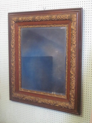 A rectangular plate mirror contained in a gilt and mahogany  frame 36"