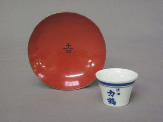 A circular porcelain Sake cup and a circular red lacquered dish