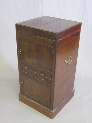 A Georgian mahogany enclosed wash stand with hinged lid, the  base fitted a cupboard above 2 short and 2 long drawers, the base  fitted a cupboard enclosed by panelled doors, raised on a  platform base 18"