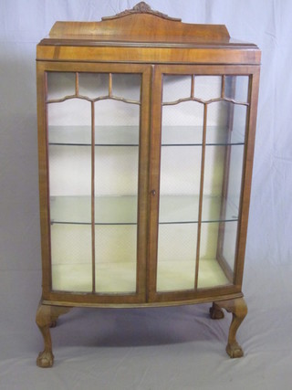 A 1930's walnut bow front display cabinet, the shelved interior enclosed by astragal glazed panelled doors, raised on cabriole ball  and claw supports 29"