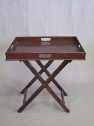 A mahogany butler's tray raised on a folding stand
