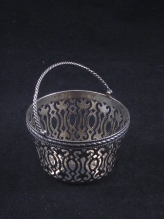 An Edwardian circular pierced silver basket with swing handle, London  1900 by Walker & Hall, 3 ozs