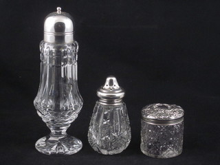 A cylindrical cut glass sugar sifter with silver lid, a cylindrical dressing table jar with silver lid and a glass sugar sifter with  plated lid