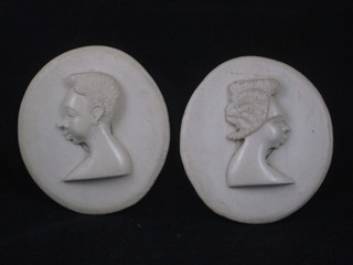 2 circular carved ivory plaques depicting a lady and gentleman 4  1/2"