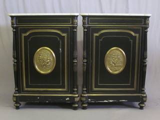 A pair of 19th Century ebonised side cabinets with white veined marble tops, enclosed by panelled doors with gilt metal plaques  to the front - 1 marble top chipped, 30"   ILLUSTRATED