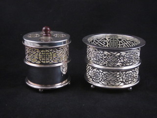 A cylindrical pierced Oriental silver plated tea light holder and a pierced white bottle coaster