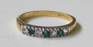 A gilt metal ring set white and green stones