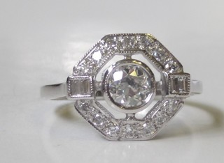 An 18ct white gold Art Deco style dress ring set a circular  diamond, 4 baguette diamonds to the shoulders and surrounded   by numerous diamonds, approx 0.85ct