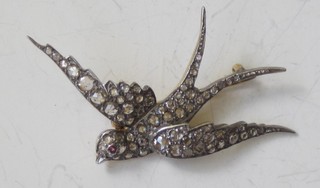 A brooch in the form of a diving dove set diamonds and a ruby  eye