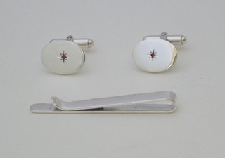 A pair of oval silver cufflinks set red stone and a silver tie clip