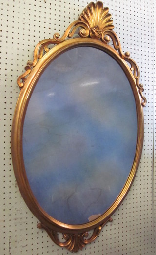 An oval bevelled plate wall mirror contained in a decorative gilt  frame 37"