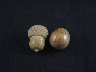 A carved ivory trinket box in the form of an acorn 1 1/2"  containing 3 dice together with an egg shaped trinket box containing 3 dice