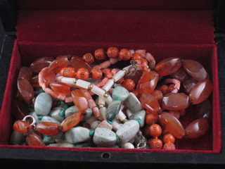 A black leather jewellery box containing a collection of hardstone  beads