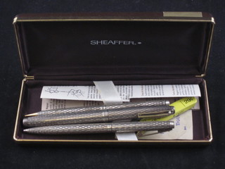 A Sheaffer fountain pen contained in a silver case, do. ball point and do. propelling pencil