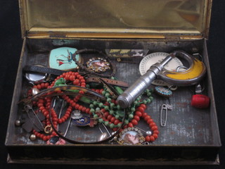 A tin containing a collection of costume jewellery