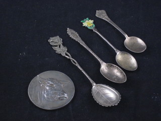 A silver medallion decorated a bulls head and 4 various silver spoons