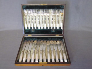 A set of 12 silver plated fish knives and forks with mother of pearl handles, contained in an oak canteen box