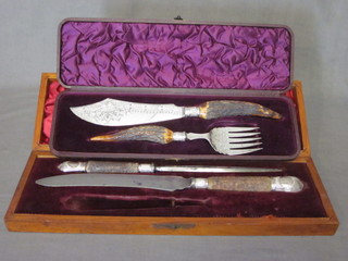 A pair of silver plated fish servers with stag horn handles  together with a 2 piece carving set comprising steel and knife