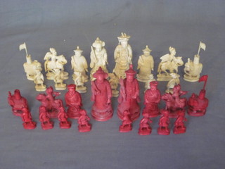 An Oriental red and white carved ivory chess set