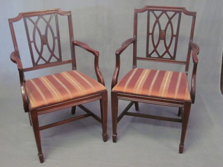 A pair of Edwardian mahogany carver chairs with upholstered  drop in seats, raised on square tapering supports with H framed  stretchers