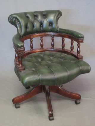 A mahogany tub back revolving office chair, upholstered in green leather