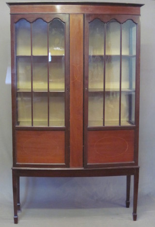 An Edwardian inlaid mahogany bow front display cabinet enclosed by astragal glazed panelled doors, raised on square  tapering supports 42"