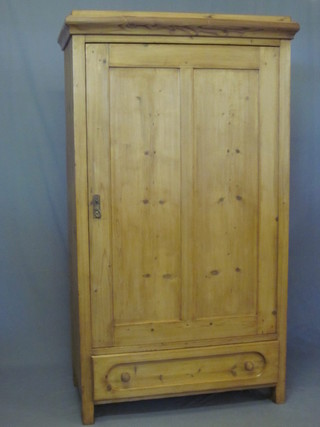 A Continental stripped and polished pine cabinet with moulded cornice, the shelved interior enclosed by a panelled door, the  base fitted 1 long drawer 40"