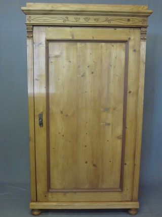 A pine cupboard with moulded cornice, the shelved interior enclosed by panelled doors, raised on bun feet 40"