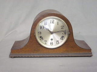 A chiming mantel clock with silvered dial and Arabic numerals, contained in an oak Admiral's hat shaped case