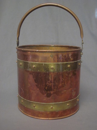 A circular copper and brass coal box with swing handle