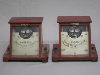 A voltmeter contained in an oak case and an amp meter contained  in a sloped mahogany case 7"