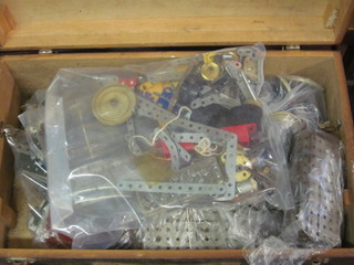 A plywood box with hinged lid containing a collection of  unpainted sections of Meccano