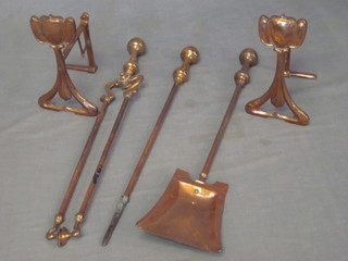 A pair of copper Art Nouveau fire dogs and a brass 3 piece  fireside companion set