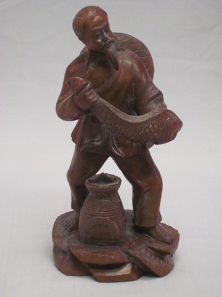 A carved Oriental figure of a fisherman 8"