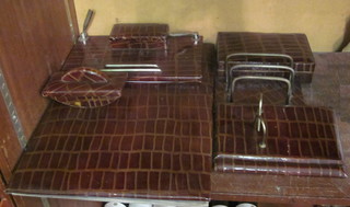 A 6 piece crocodile effect finished desk set comprising  rectangular blotter, ink blotter, pen stand with stamp box,  cigarette box, 3 bar letter rack and pen rest