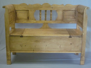 A Continental stripped and polished pine settle, the seat with hinged lid 48"