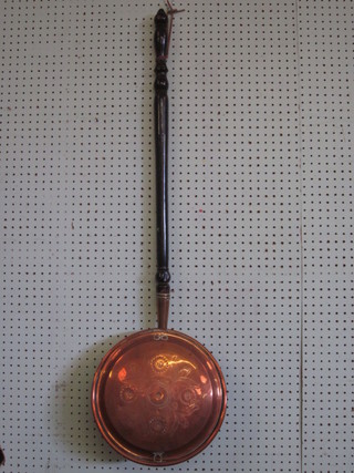 A Victorian copper warming pan with turned ebony handle