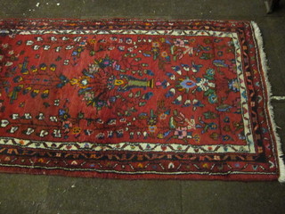 An Afghan red ground and floral patterned runner 121" x 33"
