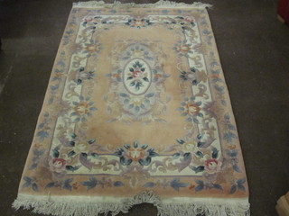 A peach coloured floral patterned Chinese rug 73" x 48"